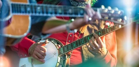 Photo of men playing guitars and banjos.