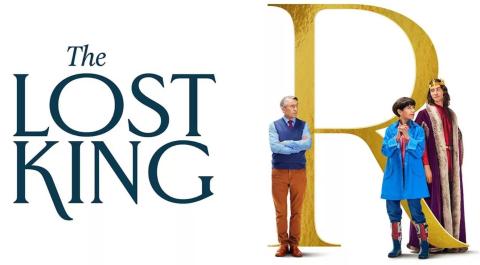 On a white background, the title 'The Lost King' in large dark lettering is on the left. A large capital letter 'R' is on the right, with three characters from the film standing around it. To the left, looking annoyed, is Steve Coogan's character John Langley, staring toward the other two characters, Sally Hawkins' character Phillipa Langley and Harry Lloyd's character, the ghost of Richard III.