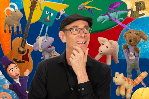 A composite photo of puppeteer Tom Knight and about a dozen of his puppets, a guitar, and colorful shapes behind him. He looks excited and struck-by-inspiration as he looks up at one of his puppets with his hand on his chin.