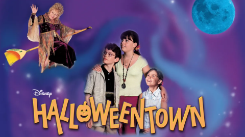 Wide image of the main characters in the movie 'Halloweentown' from 1998, with a swirly blue and purple background. The title is in yellow and one character, a witch, is on a broom in the upper corner.