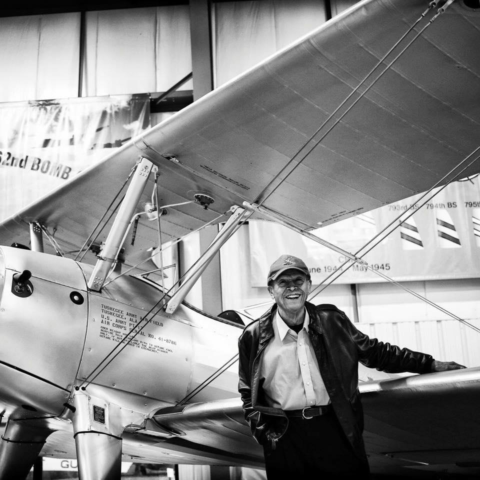 Airman James Sheppard poses in front of a small plane.